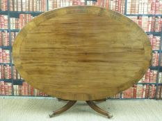 An oval mahogany tilt-top table with line inlaid and crossbanded rosewood surround raised on brass
