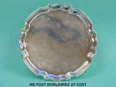 A hallmarked silver salver with shaped edge, raised on three feet Ldn 1970 maker HB, diameter 20.