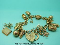 A 9ct gold charm bracelet with twenty 9ct and yellow metal charms (37.
