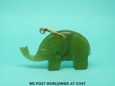 A jadeite pendant in the the form of an elephant with silver gilt mount.