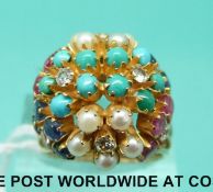 A yellow metal ring set with rubies, sapphires, pearls,