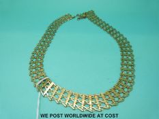 A yellow metal necklace marked 333 of zigzag lattice design (25.