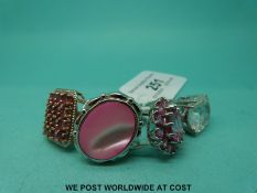 Four silver rings variously set with pink stones including sapphires and mother of pearl