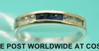 An 18ct white gold half eternity ring set with three square sapphires and six square diamonds (size