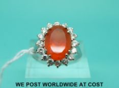 An 18ct white gold ring set with an oval cut fire opal surrounded by diamonds with original receipt