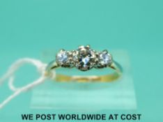 An 18ct gold ring set with three diamonds in a platinum setting,