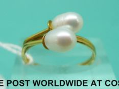 A 14ct gold ring set with two pearls (size O)