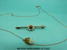 A yellow metal brooch set with an amethyst surrounded by pearls together with a yellow metal