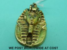 A yellow metal pendant in the form of a Pharaoh with sapphire eyes (length 4cm, 26.