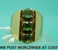 A yellow metal ring marked 585 set with three peridot (size O)