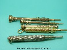 Four yellow metal propelling pencils and white metal example.