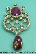 A yellow metal brooch set with round cut diamonds and a star ruby cabochon over a briolette ruby of