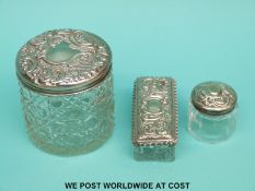 Three cut and other glass dressing table items with hallmarked silver tops
