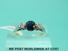 An 18ct gold ring set with a sapphire flanked by diamonds in a platinum setting (size N)