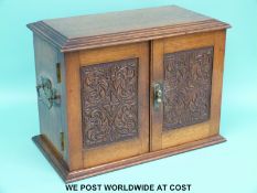 An early 20thC oak smoker's box, the doors opening to reveal drawers,