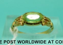 A yellow metal ring set with an oval peridot (size I)