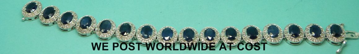 A 14ct white gold bracelet set with 16 oval cut sapphires surrounded by diamonds,