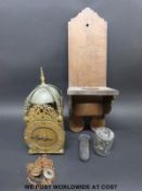 A large brass wall mounted lantern clock on oak bracket