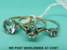 A yellow metal ring set with a large round cut clear stone,