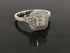 An 18ct white gold diamond cluster ring, the central princess cut stone of 0.