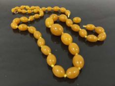 A nineteenth century amber necklace of forty-five graduated butterscotch lozenges,