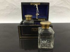 A pair of cased crystal decanters, the gilt lids with monogram,