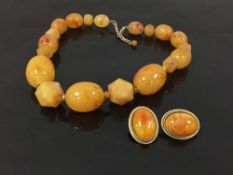 A nineteen beaded amber necklace, together with a pair of oval earrings.