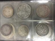 A coin album containing a quantity of Victorian and later crowns and half crowns,
