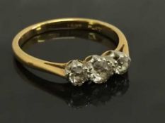 An 18ct gold old cut three stone diamond ring, size M / N.