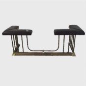 An adjustable brass club fender with brown leather studded seat, closed width 154 cm.