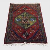 A wool Eastern rug on red ground with multicoloured border,163 cm x 118 cm.