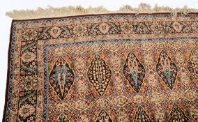 A Tabriz carpet:, of garden design, the panelled field with varying shades of brown,