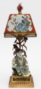 A French porcelain and ormolu 'chinoiserie' table lamp: the square section shade with figure finial