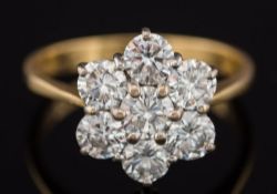 An 18ct gold and diamond seven stone circular cluster ring: with circular brilliant-cut diamonds