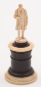 A small Dieppe ivory figure of Napoleon: wearing a long tail coat, one hand inside his waistcoat,