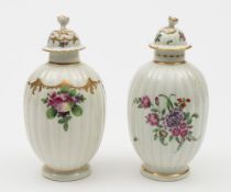 Two Worcester tea canisters and covers: each of reeded ovoid form with flower finials,