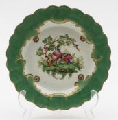 A redecorated Worcester plate: painted with exotic birds in a landscape vignette within a gilt