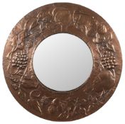 An Arts and Crafts influence circular copper wall mirror: the circular mirror plate enclosed in an