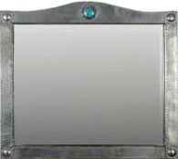 A Liberty style hammered pewter wall mirror: of arched outline with enamel boss to the central arch