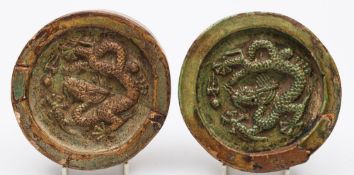 A pair of Chinese green glazed pottery circular roof tiles: the recessed centre of each moulded in