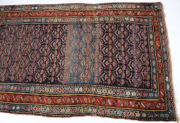 A Caucasian rug:, the indigo and pastel blue field with an all over design of flowering plants,