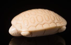 A Japanese carved ivory netsuke: Meiji period (1864-1912), in the form of a stylised turtle, signed,