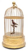A French clockwork automaton singing bird in cage: the clockwork operated feathered bird on a