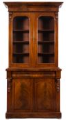 A Victorian mahogany bookcase:, the upper part with an overhanging ledge and ogee moulded cornice,