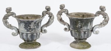 A pair of lead garden urns: of neoclassical form with half reeded decoration,