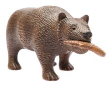 A Black Forest carved linden wood bear: holding a fish in it's mouth,