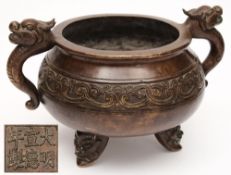 A large Chinese bronze tripod censer: of squat circular form, with banded scrolling decoration,