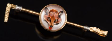 A reverse painted crystal intaglio, gold backed fox mask mounted 'crop' bar brooch:,