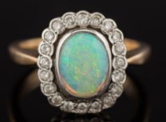 A 9ct gold, opal and diamond oval cluster ring: the oval opal approximately 9mm long x 7mm wide,