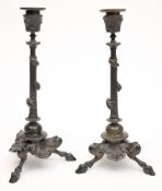 A pair of 19th century bronze candlesticks: with floral decorated urn-shaped nozzles on reeded
